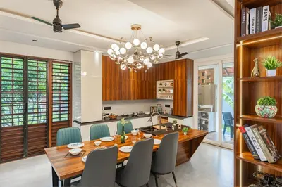 a dining room with a table and chairs and a kitchen at Ekta Pool Farmstay Pollachi in Pollāchi