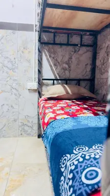 a bed with a red and blue blanket on it at Mysuru dorm-sgh in Mysore