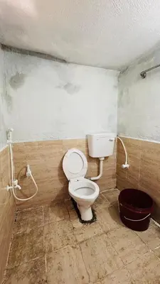 a dirty bathroom with a toilet in a room at Muffintrip stays camp N trek in Kūkkāl