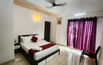 a bedroom with a bed and a window at Nestora Suites in Kozhikode