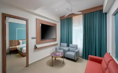 a hotel room with a bed and a couch and a chair at REGAL HEIGHTS in Ernakulam