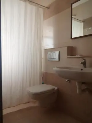 a bathroom with a toilet and a sink and a mirror at Kohinoor Hotels in Erode