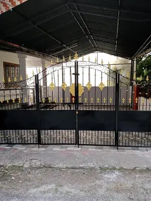 a black gate with gold umbrellas on it at Cloud Nine Home Thrissur in Trichūr
