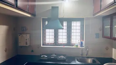 a kitchen with a sink and a stove and windows at Cloud Nine Home Thrissur in Trichūr