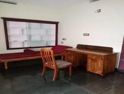 a room with a desk and a bench and a chair at Cloud Nine Home Thrissur in Trichūr