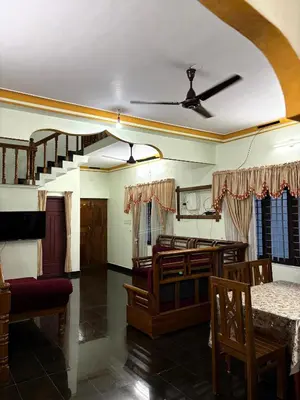 a living room with a ceiling fan and a dining room at Cloud Nine Home Thrissur in Trichūr