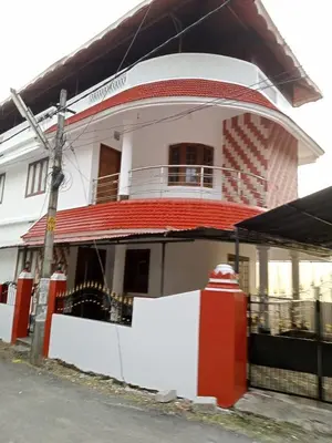 a white and red building with a red roof at Cloud Nine Home Thrissur in Trichūr