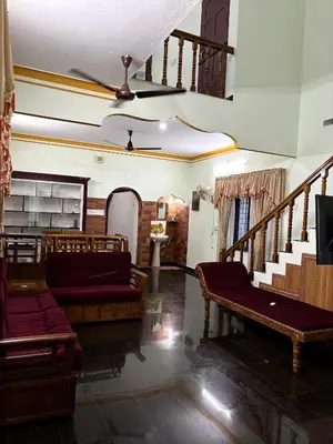 a living room with a couch and a staircase at Cloud Nine Home Thrissur in Trichūr