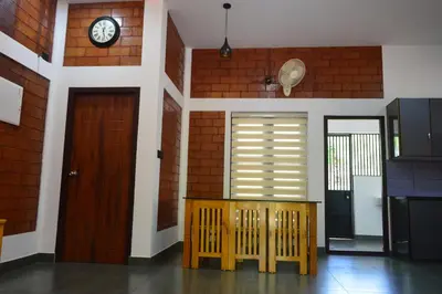 a room with a door and a clock on the wall at DreamWoods Cottage in Kelakam