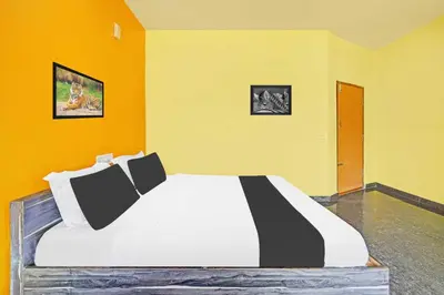 a bedroom with a large bed in a yellow room at Hotel O Coorg Hanging Bridge in Kushālnagar