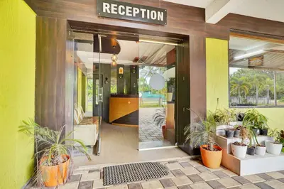 an entrance to a hotel with potted plants in front of the door at Hotel O Coorg Hanging Bridge in Kushālnagar