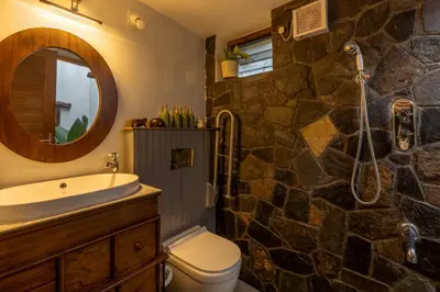 a stone bathroom with a sink and a shower at The Oneness Living- Seasonal Heritage stay with Tholpaavakoothu nights in Pazhayannūr
