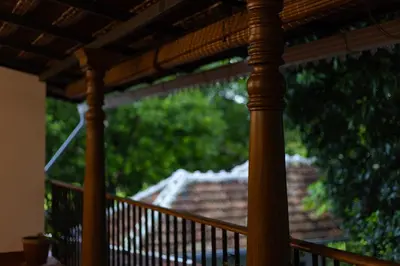 a wooden porch with a view of a roof at The Oneness Living- Seasonal Heritage stay with Tholpaavakoothu nights in Pazhayannūr