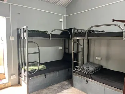 a room with three bunk beds in a room at Bykerstops in Ooty