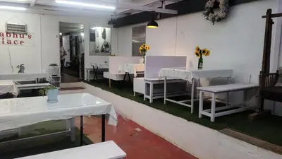a dining room with white tables and white chairs at Bykerstops in Ooty