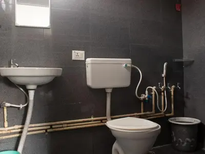 a bathroom with a toilet and a sink at Bykerstops in Ooty