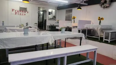 a group of tables with white table cloths in a room at Bykerstops in Ooty