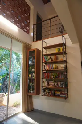 a room with a book shelf with books at Malhar - Your home away from home in Bālūssheri