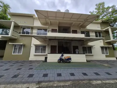 a scooter parked in front of a house at Zainab Apartment in Perintalmanna