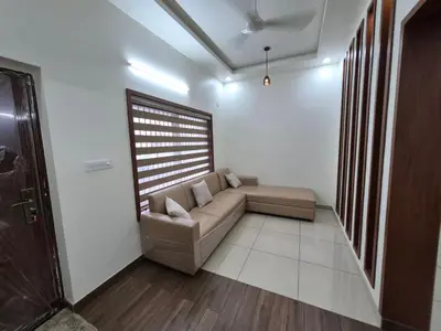 a living room with a couch and a window at Zainab Apartment in Perintalmanna