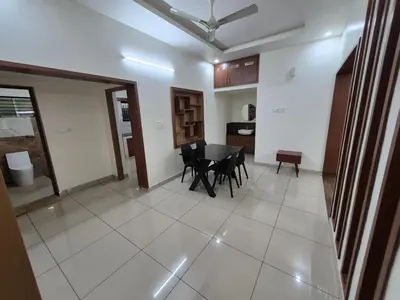 a living room with a table and chairs in it at Zainab Apartment in Perintalmanna