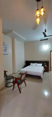 a bedroom with a bed and a table in it at SAF RESIDENCY mukkam in Mukkam
