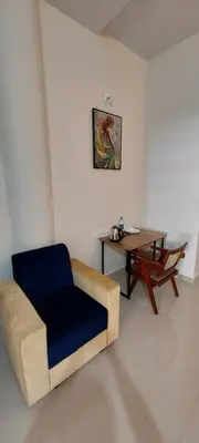 a living room with a chair and a table at SAF RESIDENCY mukkam in Mukkam