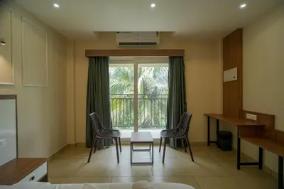 a room with two chairs and a table and a window at AR Suites Kothamangalam in Kotamangalam