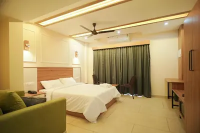 a hotel room with a bed and a living room at AR Suites Kothamangalam in Kotamangalam