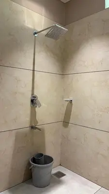 a bathroom with a shower with a bucket at IRU Homes - Private Family Stay with Pool in Ambalavayal