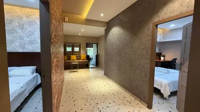 a hotel room with two beds and a mirror at IRU Homes - Private Family Stay with Pool in Ambalavayal