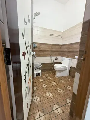 a bathroom with a toilet and a sink at SRI Villa Rooms in Wayanad - Family Villa Stay with Mountain views in Vayittiri
