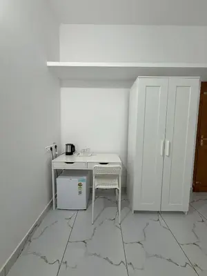 a white room with a table and a chair at SRI Villa Rooms in Wayanad - Family Villa Stay with Mountain views in Vayittiri
