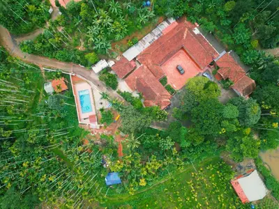 an aerial view of a house with a yard at Kudajadri Drizzle Homestay in Kaniyāmbetta