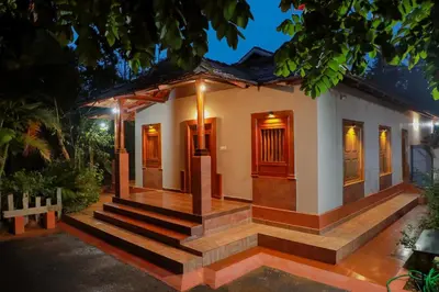 a house with a staircase leading up to it at Kudajadri Drizzle Homestay in Kaniyāmbetta