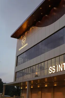 a building with a s institute sign on it at Hotel S S International Coorg in Suntikoppa