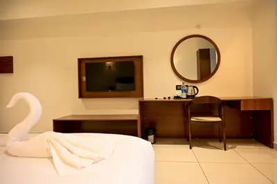 a hotel room with a mirror and a bed and a desk at Hotel S S International Coorg in Suntikoppa