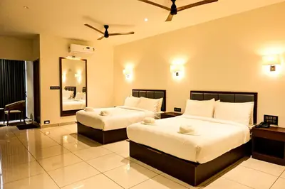a hotel room with two beds and a mirror at Hotel S S International Coorg in Suntikoppa