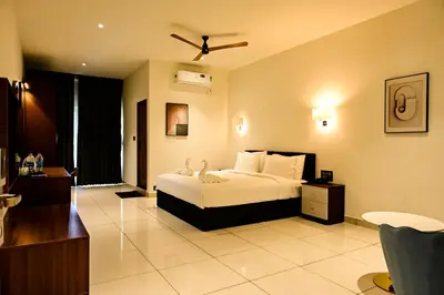a bedroom with a bed and a living room at Hotel S S International Coorg in Suntikoppa