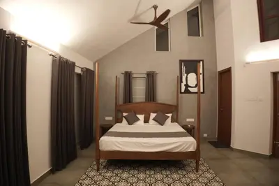 a bedroom with a bed and a ceiling fan at Coastline 4Bedroom cliffside villa in Elattūr