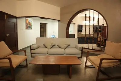 a living room with a couch and chairs and a table at Coastline 4Bedroom cliffside villa in Elattūr