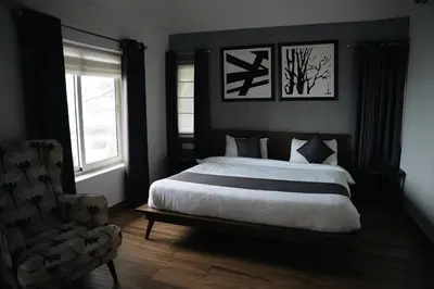 a bedroom with a large bed and a chair at Coastline 4Bedroom cliffside villa in Elattūr