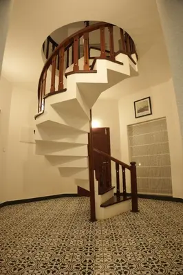 a spiral staircase in a room with a tile floor at Coastline 4Bedroom cliffside villa in Elattūr