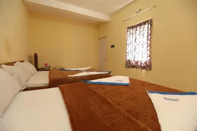 a room with two beds and a window with a window at Rainbow Cottages-Budget Friendly rooms in Ooty