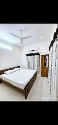 a bedroom with a bed and a ceiling fan at Mariya Stay in Kanjikode