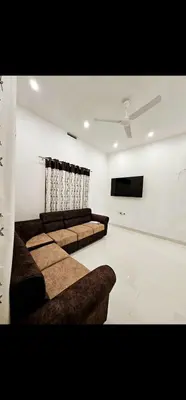 a living room with couches and a flat screen tv at Mariya Stay in Kanjikode