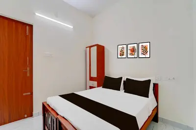 a bedroom with a bed and a wooden door at Hotel O Coimbatore Peelamedu Railway Station in Coimbatore