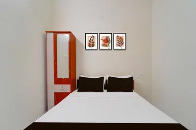 a bedroom with a bed and two pictures on the wall at Hotel O Coimbatore Peelamedu Railway Station in Coimbatore