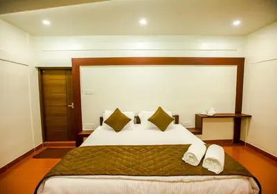 a bedroom with a large bed with two pillows at Tusker Inn Forest Lodge in Pulpally