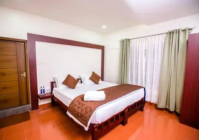 a bedroom with a bed and a large window at Tusker Inn Forest Lodge in Pulpally